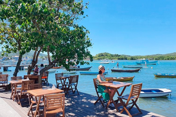 Imagens de pessoas almoçando no Cabo Frio em dia ensolarado 