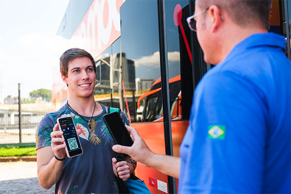 Imagem de jovem mostrando sua passagem para o motorista antes de embarcar no ônibus