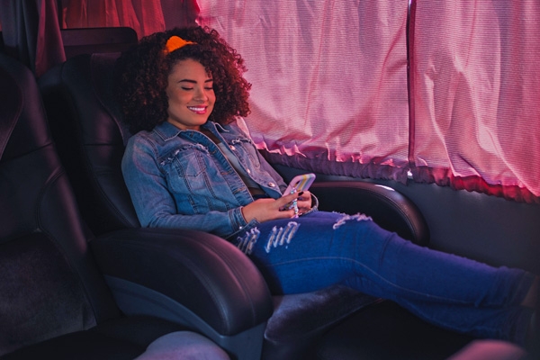 Imagem de passageira sorrindo sentada no ônibus da wemobi 
