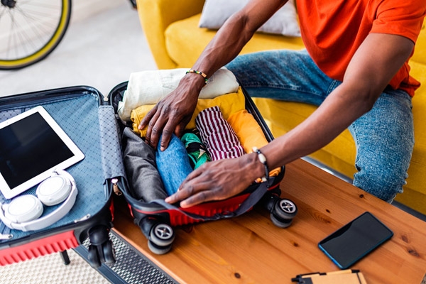 Imagem de homem arrumando mala para viajar