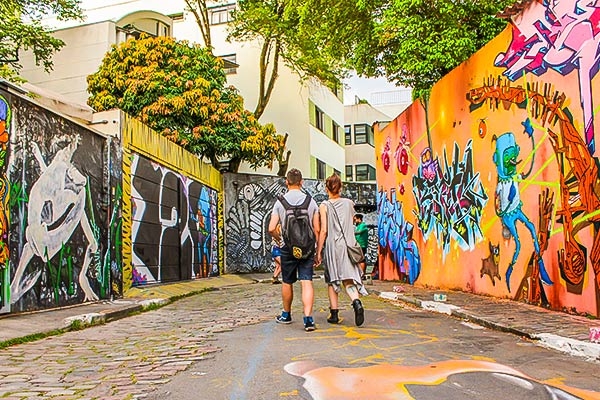 Imagem do Beco do Gato em São Paulo com duas pessoas prestigiando 
