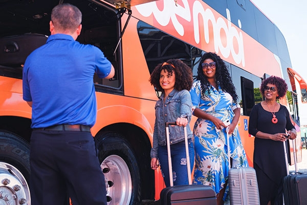 Passageiros colocando as malas no ônibus