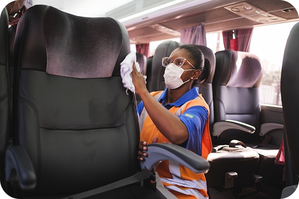 Foto de uma mulher fazendo a higienização do ônibus